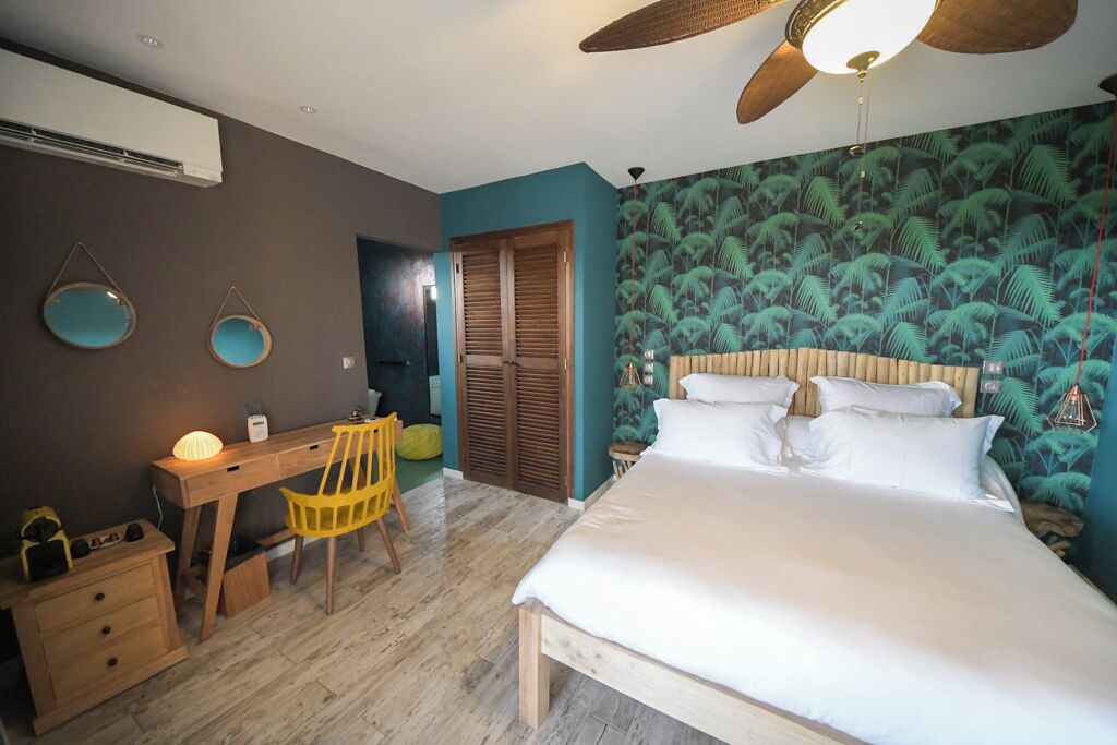 A bedroom with a bed, a desk, and a chair.