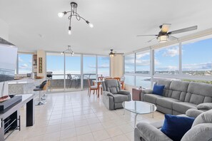 A spacious living area with a balcony, a kitchen, and a dining area. - Two Bedroom Beach Front Condo with Amazing Ocean View (Las Lajas)