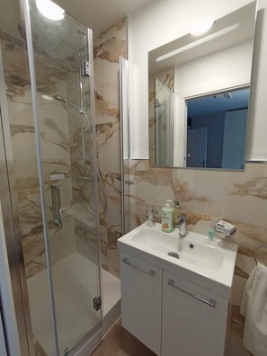 Regadera, secadora de cabello, toallas, papel de ba ño 