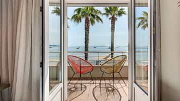 Ein Balkon mit zwei Stühlen und Blick aufs Meer.