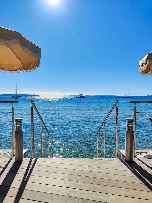 Plage privée, sable blanc, chaises longues, bar de plage