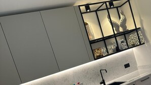 Eine moderne Küche mit Einbauofen, Spüle und Arbeitsplatte, inklusive Messerblock und Küchengerät.