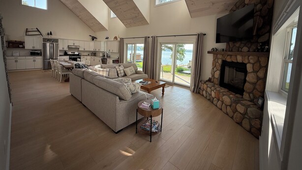 A spacious living area with a large sofa, a fireplace, and a kitchen in the background.