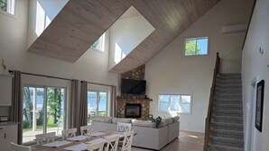 A spacious living area with a dining table, sofa, and a stone fireplace.