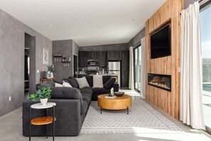 A modern living room with a sofa, coffee table, and fireplace.