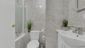 Une salle de bain moderne équipée de toilettes, d’un lavabo et d’une douche.