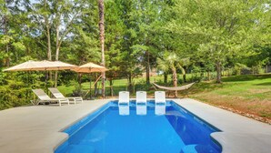 A rectangular swimming pool with a concrete deck, surrounded by trees and a hammock. - West Union Home w/ Saltwater Pool on 2 Acres! (West Union)