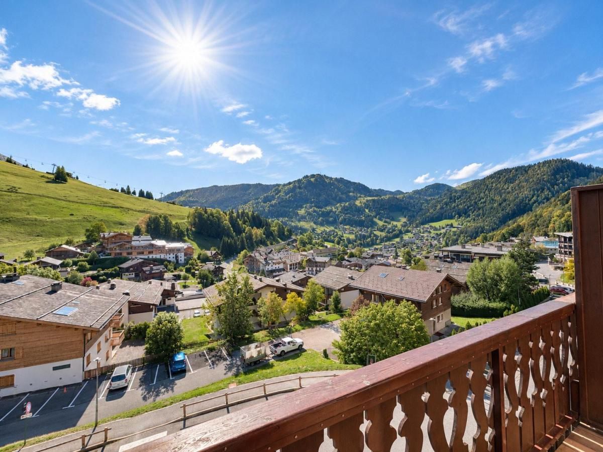 A residential area with houses, a clear sky, and a sun shining.