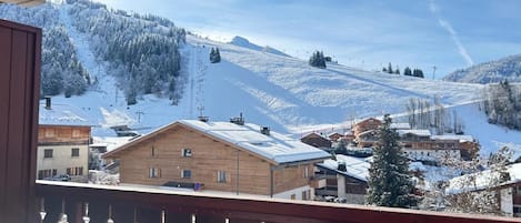 A balcony with a view of a snow-covered mountain and a town.