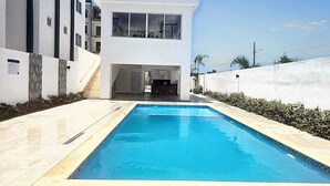 Un bâtiment moderne avec une piscine à l’avant.