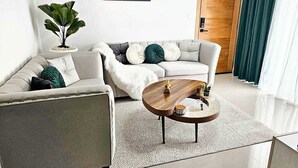 Un salon moderne avec un canapé, une table basse et un tableau décoratif au mur.