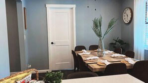 A dining area with a table set for four, a ceiling fan, a clock, and a door. - Gorgeous Florida Pool and Spa Home (Jacksonville)