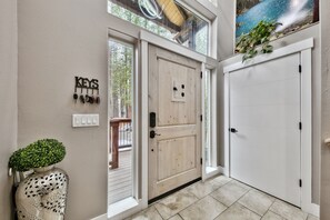 A wooden door with a keypad lock, a wall-mounted key rack, and a potted plant. -  Modern mountain home in South Lake Tahoe. Close to Lake, Ski Resorts & more.  (South Lake Tahoe)