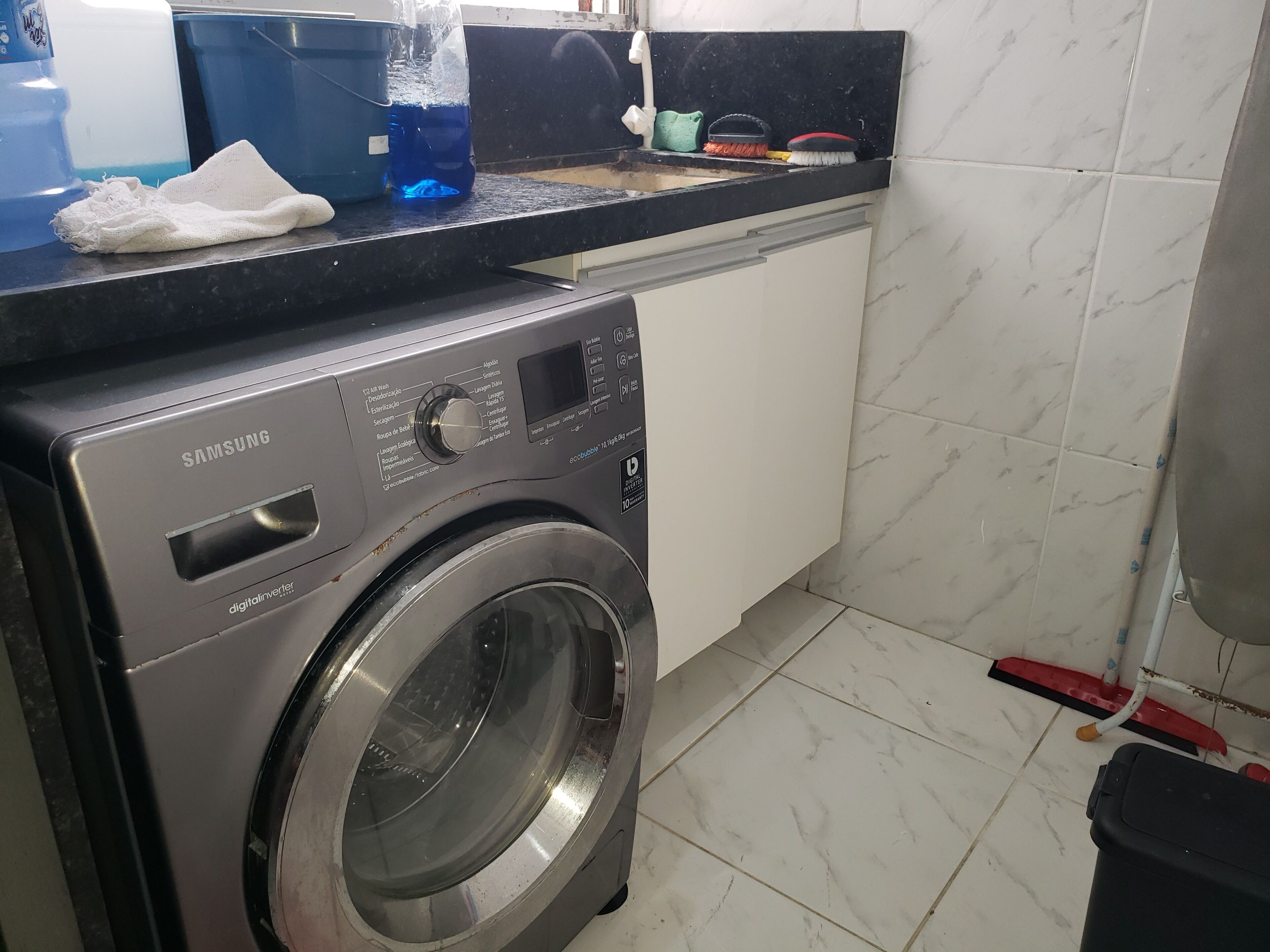 Una rentadora Samsung en una cuina amb un salvassecs de rajola i un taulell.