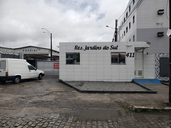 A building with a sign reading "Res. Jardins do Sul" and the number 411.
