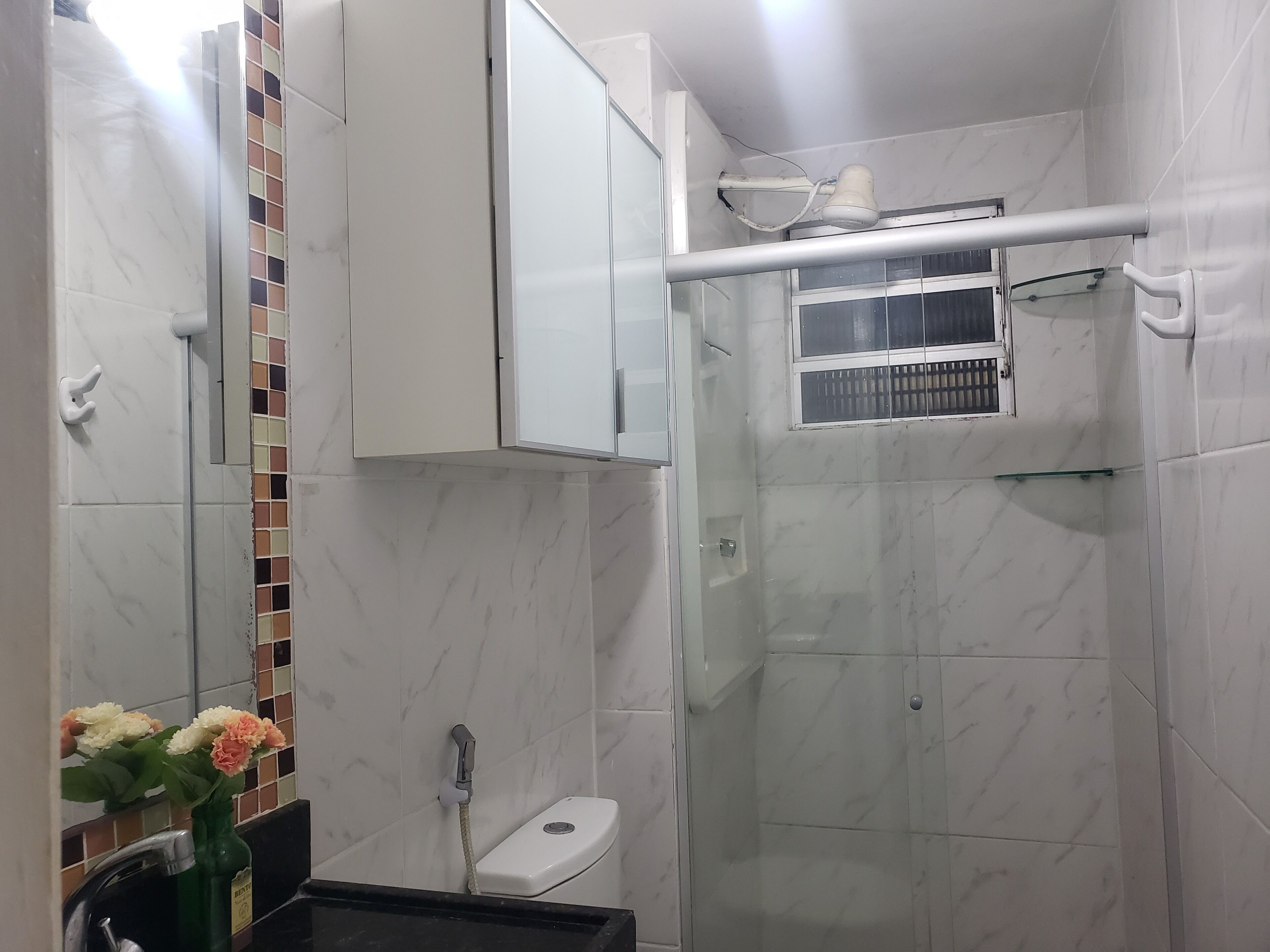Une salle de bain moderne avec une douche à parois de verre, des toilettes et un lavabo avec un miroir.