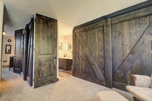 A hallway with rustic wooden doors and a large sliding barn door.