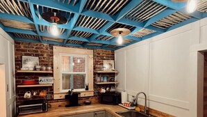 Een keuken met een geruit vloerkleed, een spoelbak en een magnetron.