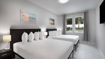 A hotel room with two beds, a large window with a view of the outdoors, and artwork on the walls.