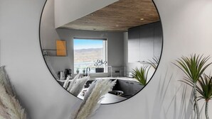 A modern kitchen with a view of a desert landscape through a large window. - Luxury Log Home with a Hot Tub. (Selfoss)
