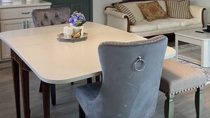 Uma sala de jantar com uma mesa, cadeiras e um lustre.