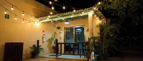 A building with a reception area, potted plants, and string lights.