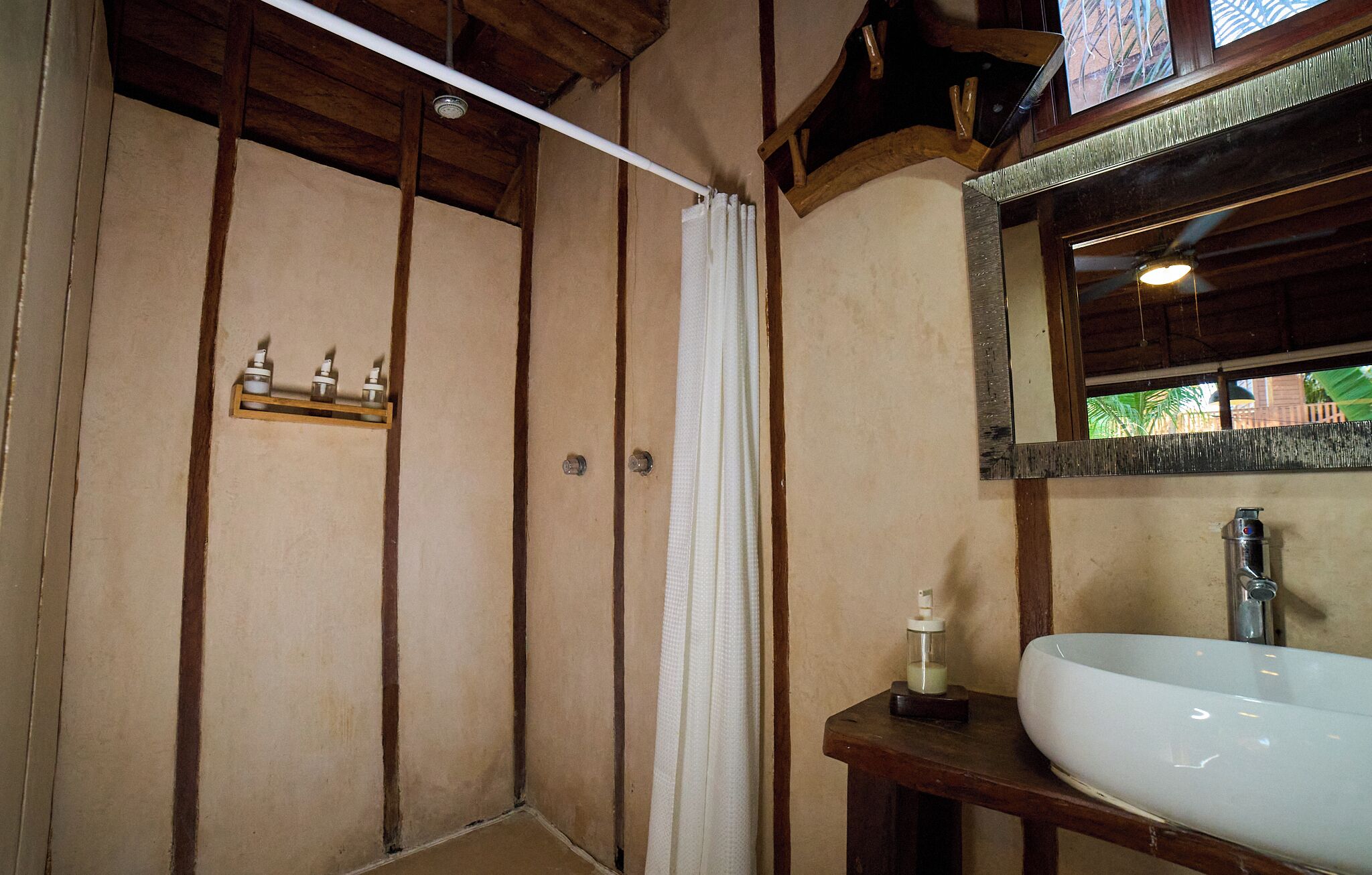 A bathroom with a shower, a sink, and a mirror.