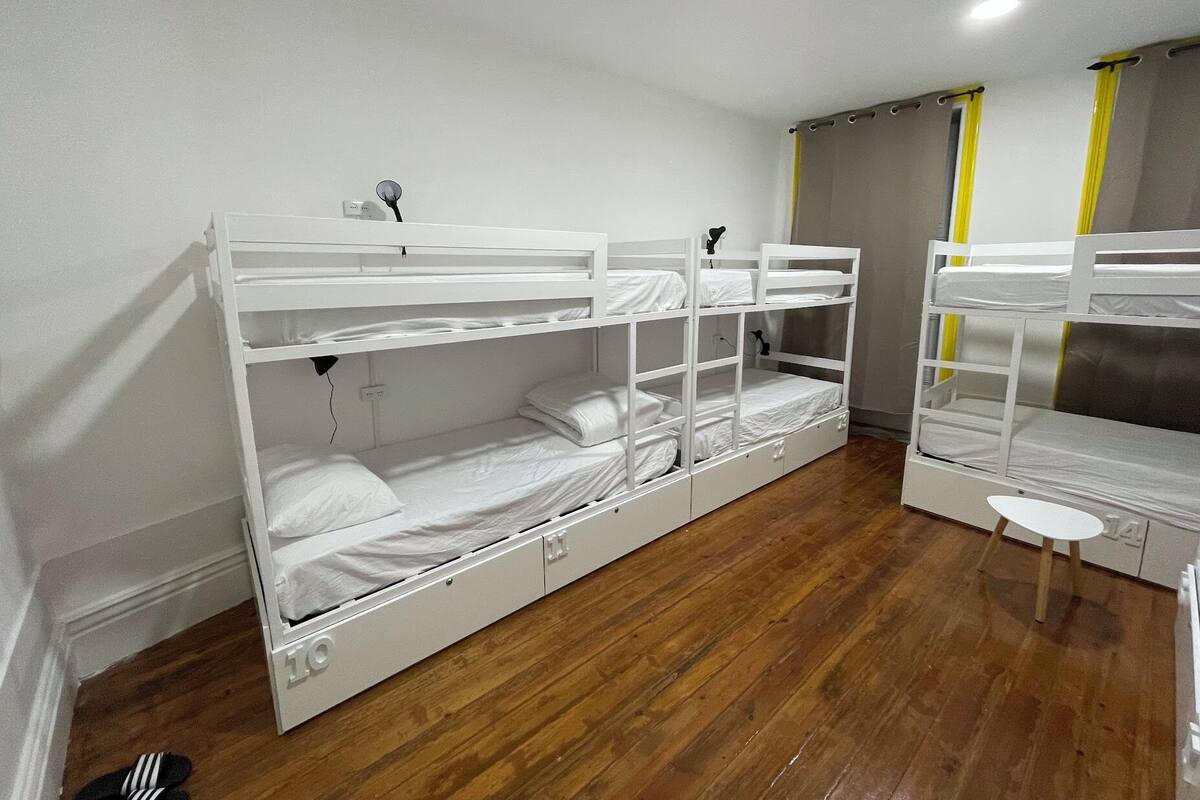A bunk bed room with a small table and a chair.