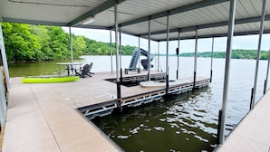 A covered dock with a kayak, a table, and chairs.