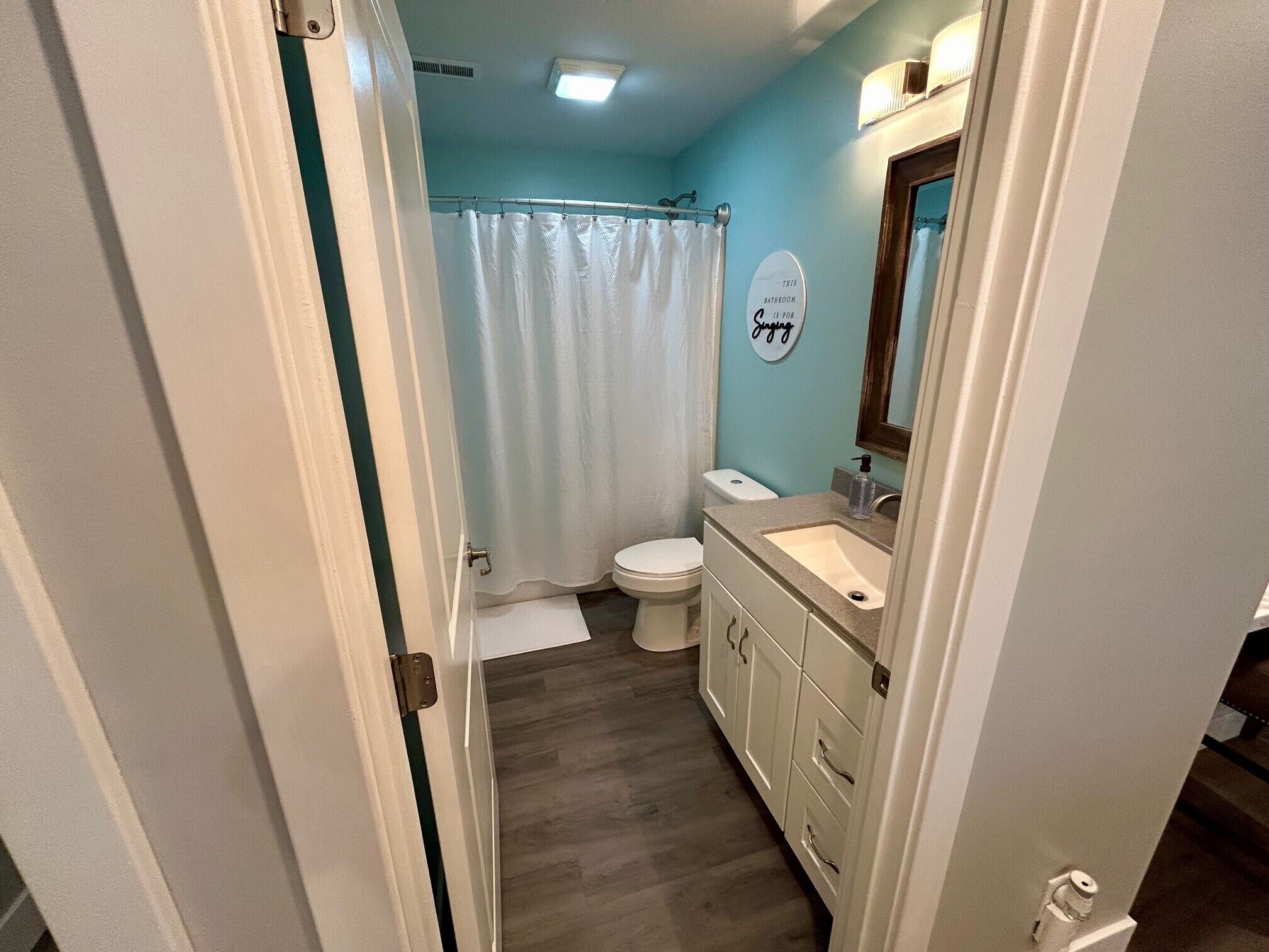 A bathroom with a toilet, sink, and shower curtain.