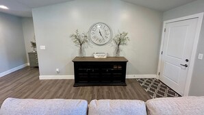 A living room with a clock, a fireplace, and a door. - Spacious & Modern 2BR Home with Attached Garage (Quincy)