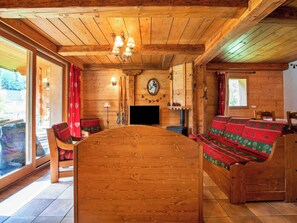A wooden interior with a large wooden table, a sofa, a television, and a fireplace. - Casa-Chalet Brizolée avec vue sur le lac à Tignes (Tignes)