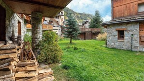 Ein malerisches Bergdorf mit Steinhäusern, Holzbalkonen und einem grünen Innenhof.