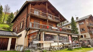 Un edificio de madera con balcón, un cartel que dice 'PRODUCTS REGIONAIS' y una pared de piedra.