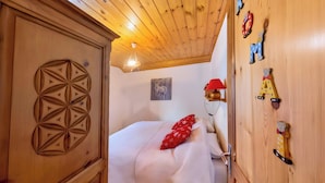 Una stanza in legno con un letto, una parete decorata con lettere dell'alfabeto e una lampada a soffitto.
