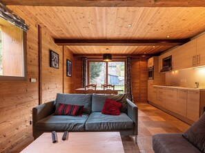 A cozy living room with a sofa, a coffee table, and a TV.