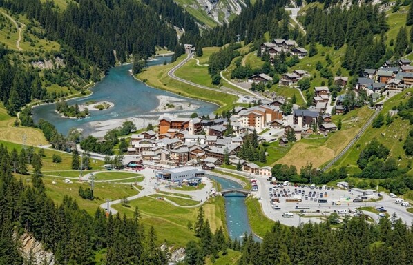 A mountainous village with a river, traditional houses, and a parking area. - Casa-Chalet du Parc Cosy apartment in Tignes (Tignes)