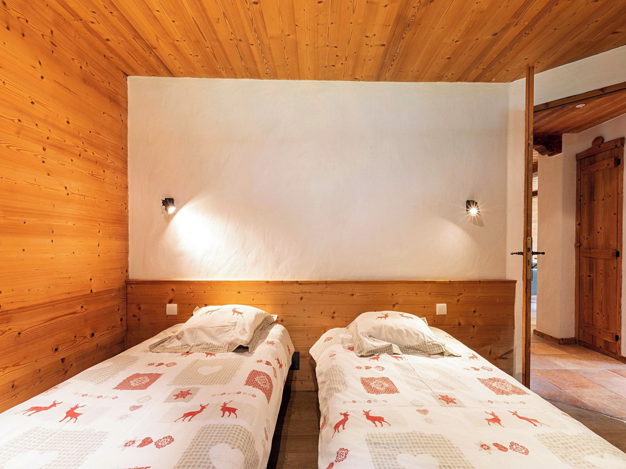 Ein Zimmer mit zwei Betten, Holzwänden und einer weißen Decke.