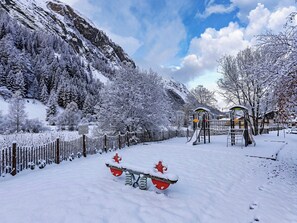 A snowy mountain landscape with a playground and a fenced area. - Casa-Chalet du Parc Cosy apartment in Tignes (Tignes)