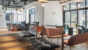 A modern office space with leather sofas, metal-framed chairs, and a glass partition. - Enclave KX - Campus Accommodation (London)