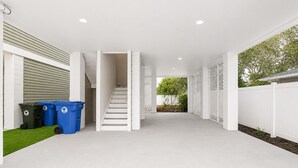 A clean, modern interior with a staircase, white walls, and a view of the outdoors.