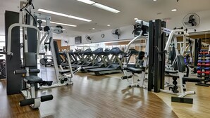 Ein Fitnessstudio mit Laufbändern, Krafttrainingsgeräten und verschiedenen Fitnessgeräten.