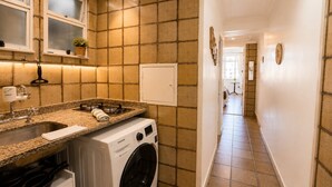 A compact kitchen with a built-in washing machine, a sink, and a stove. - Amazing sea view in Copacabana (Rio de Janeiro)