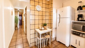 A kitchen with a white refrigerator, a microwave, and a coffee maker on the countertop. - Amazing sea view in Copacabana (Rio de Janeiro)