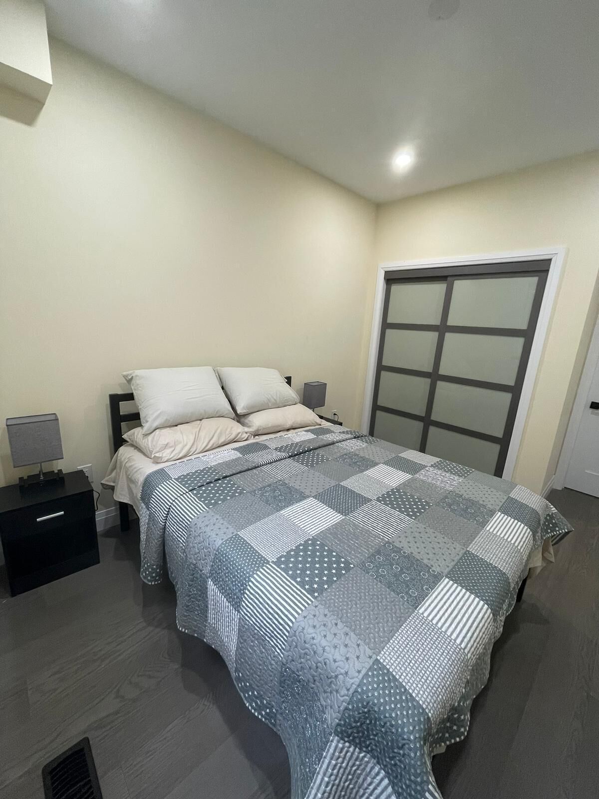 Une chambre à coucher comprenant un lit, des tables de chevet, une armoire et une petite table de nuit.