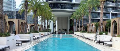 Una piscina al aire libre, camas de piscina gratis, sombrillas