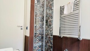 A bathroom with a shower, bidet, and a towel rack. - Capo - Single Room (Butera Apartments Luxury) (Palermo)