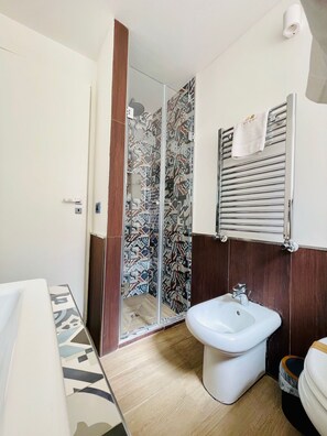 A bathroom with a shower, bidet, and a towel rack. - Capo - Single Room (Butera Apartments Luxury) (Palermo)