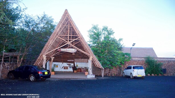 A safari lodge with a triangular roof structure, a reception area, and a stone wall. - Hillstone Safari Lodge (Kimana)