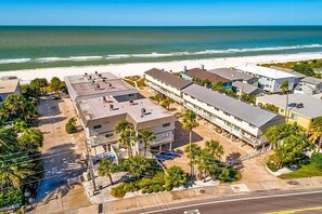 A coastal hotel with multiple buildings, a beach view, and a parking area. - Gulfside Villas Unit 11... Steps to the Beach, Heated Pool Beautiful Townhome (Indian Rocks Beach)